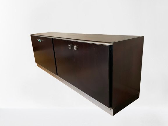 Een wandkast van donker hout met twee deuren, metalen handgrepen en een minimalistisch design, tegen een eenvoudige witte achtergrond.