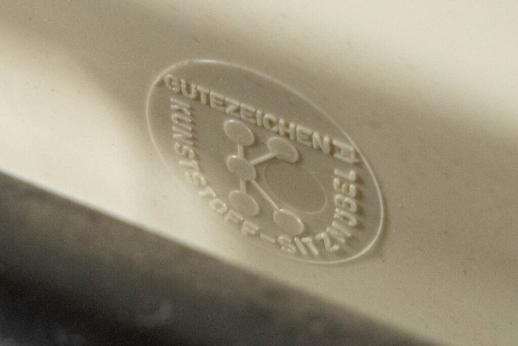 Close-up van een reliëflogo op een kunststof oppervlak, met de Duitse tekst 