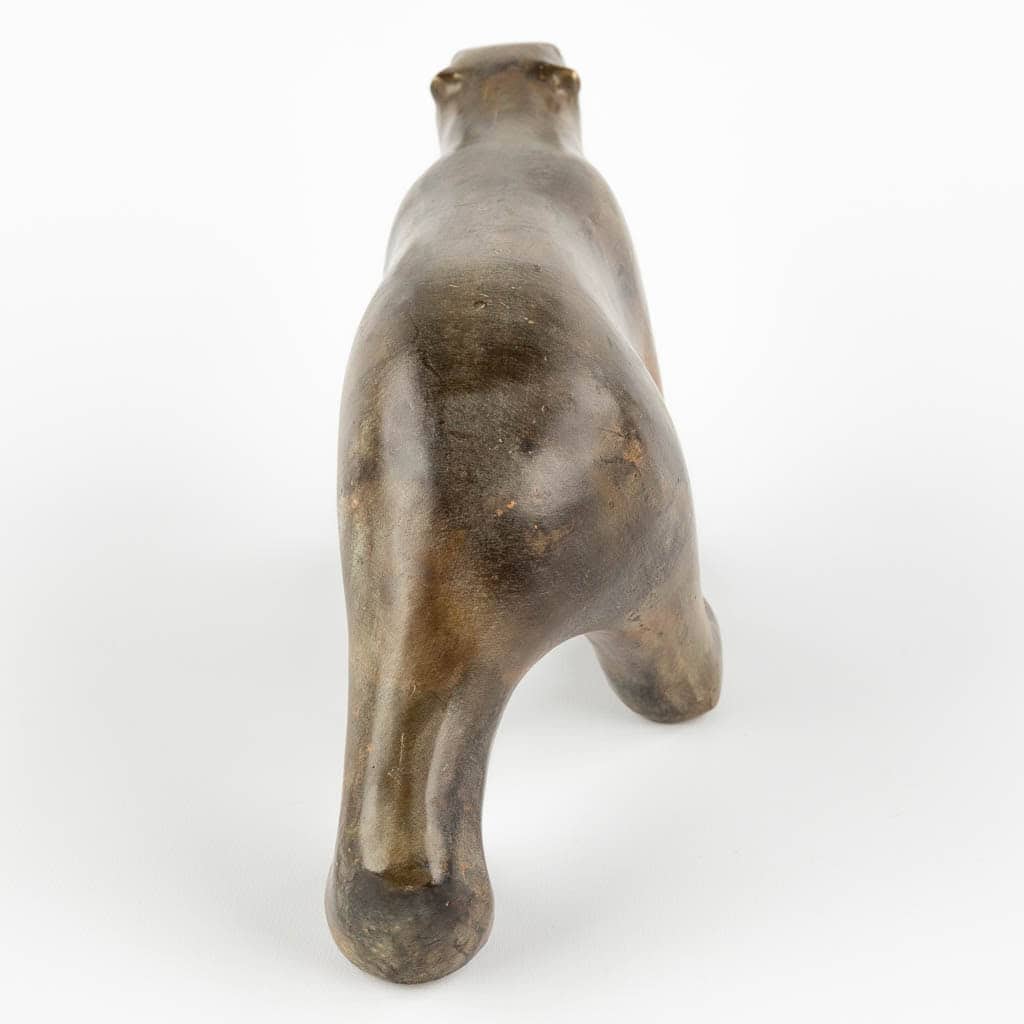 Bronzen beeld van een lopend dier, van achteren gezien, met twee achterpoten en een zichtbare staart. Het dier lijkt een glad, rond oppervlak te hebben en staat op een effen witte achtergrond.