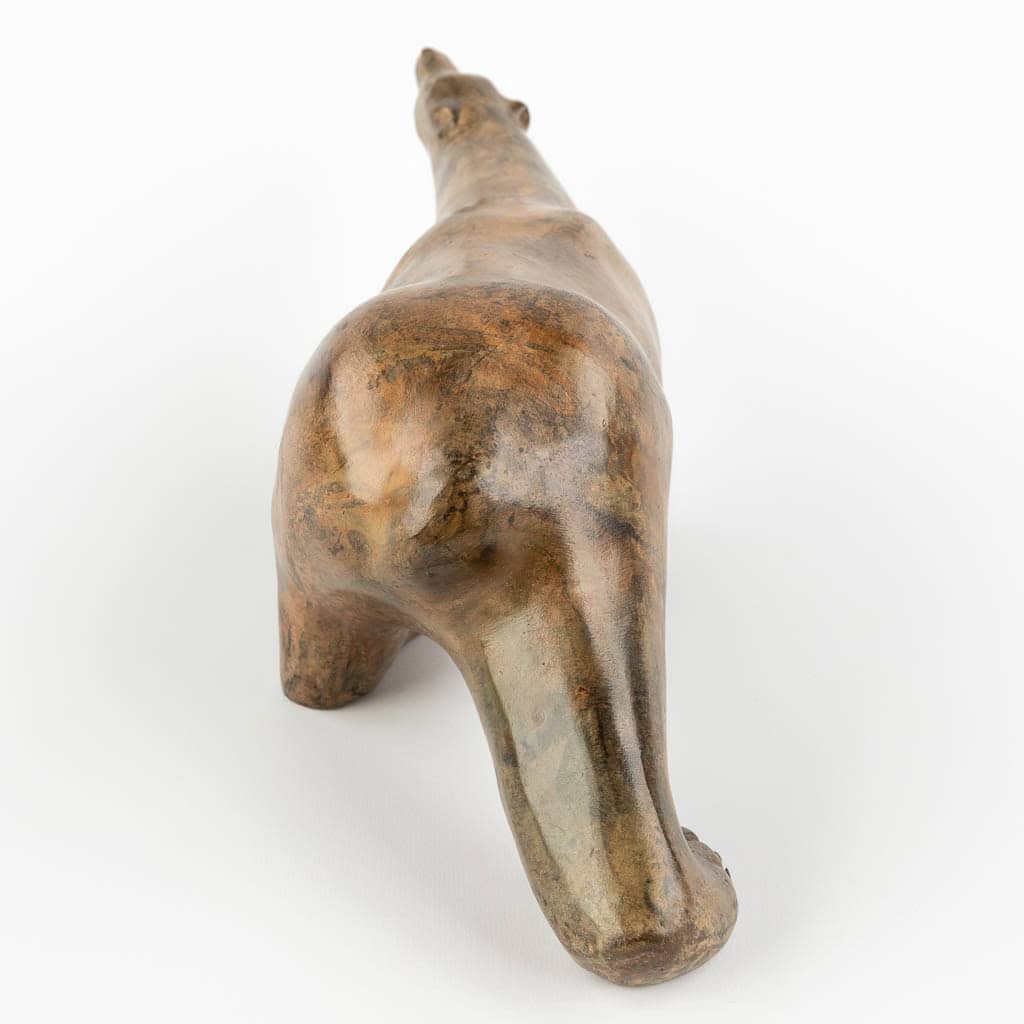 Een keramisch beeldhouwwerk van een dier, mogelijk een paard of een soortgelijk wezen, van achteren en iets van bovenaf bekeken, waarbij de rug, achterhand en staart te zien zijn op een witte achtergrond.