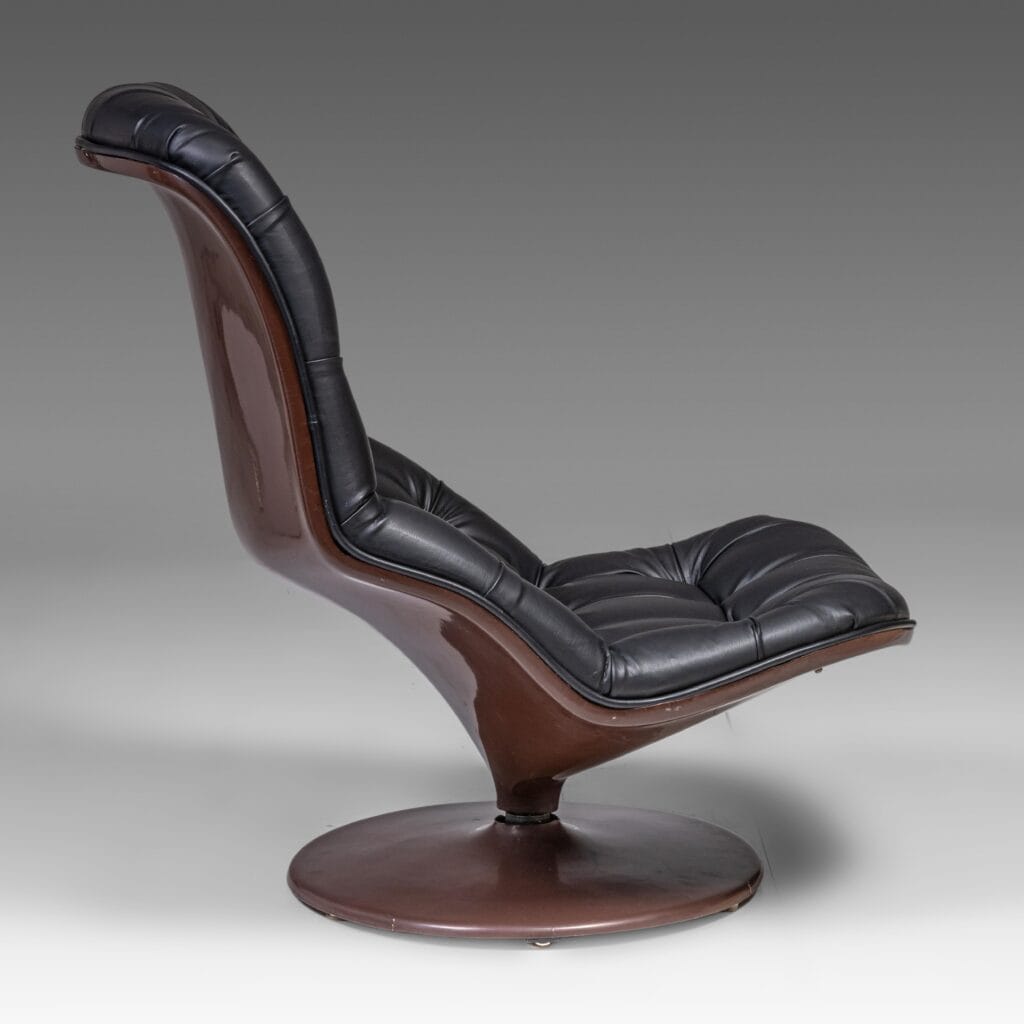 Een moderne loungestoel met een gebogen, donkerbruin onderstel en frame, met zwarte, gecapitonneerde leren bekleding. De stoel heeft een retro, mid-century modern design en staat op een ronde voet.