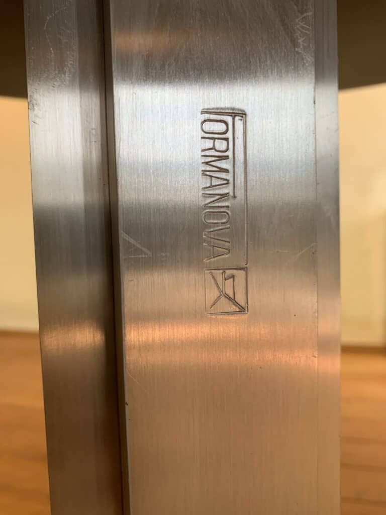 Close-up van een geborsteld metalen oppervlak met het woord 