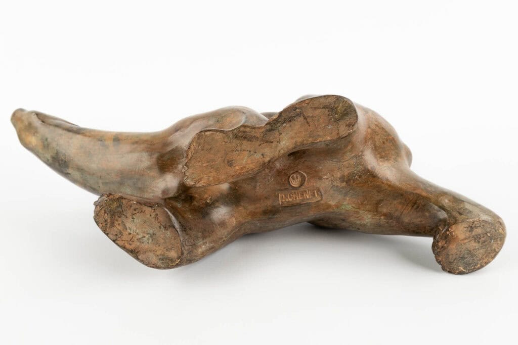 Een bronzen dierensculptuur op zijn zij, waarbij de onderkant van het beeld en gegraveerde markeringen zichtbaar zijn, waaronder de naam van de kunstenaar 